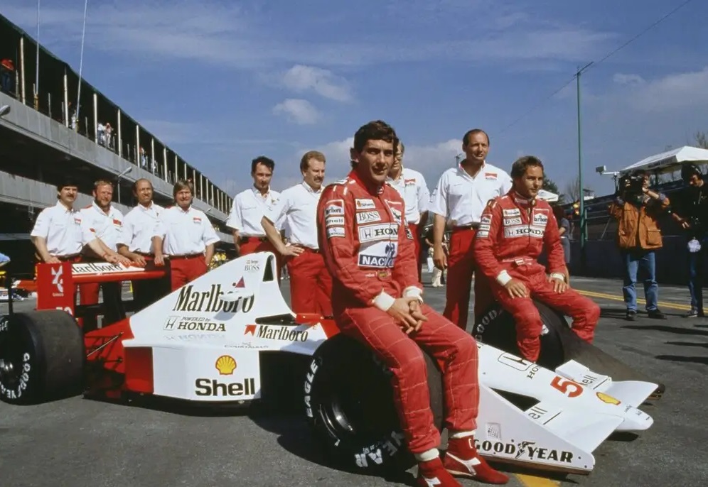 Ayrton Senna se apoia em um carro de corrida